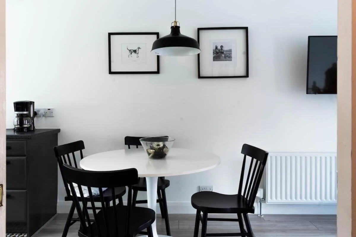 a dining room with a white table and chairs at Amica Guesthouse in Belfast